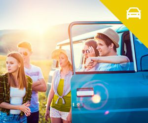 A group of young adults standing outside of a van
